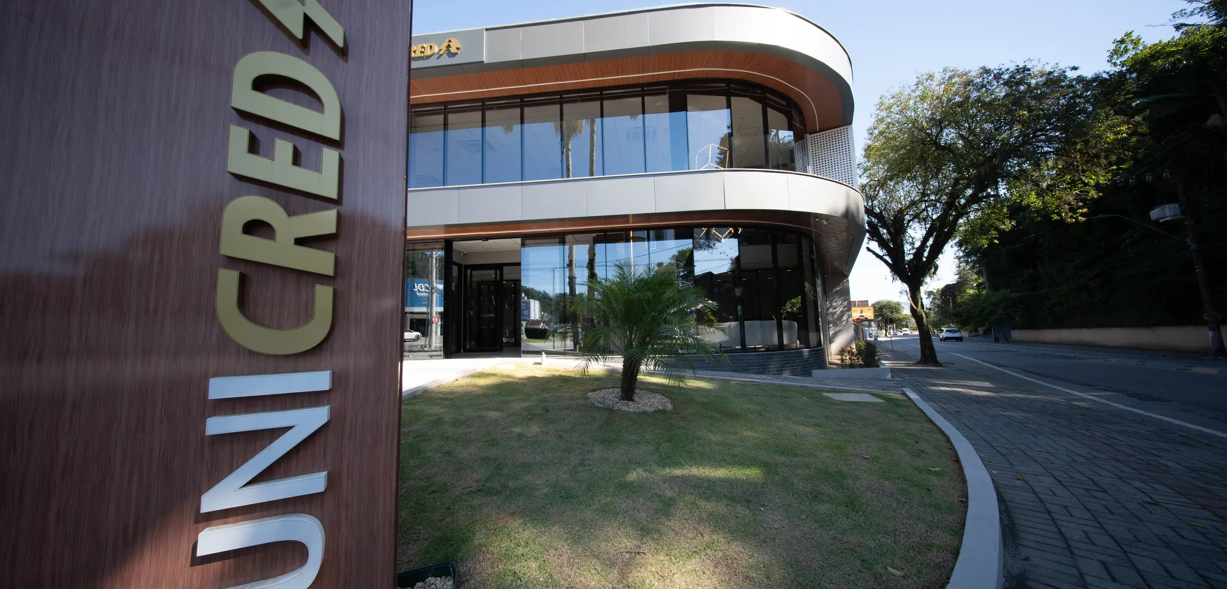 Fachada da agência Unicred entregue pela RAK Engenharia, com brise de madeira e vidro