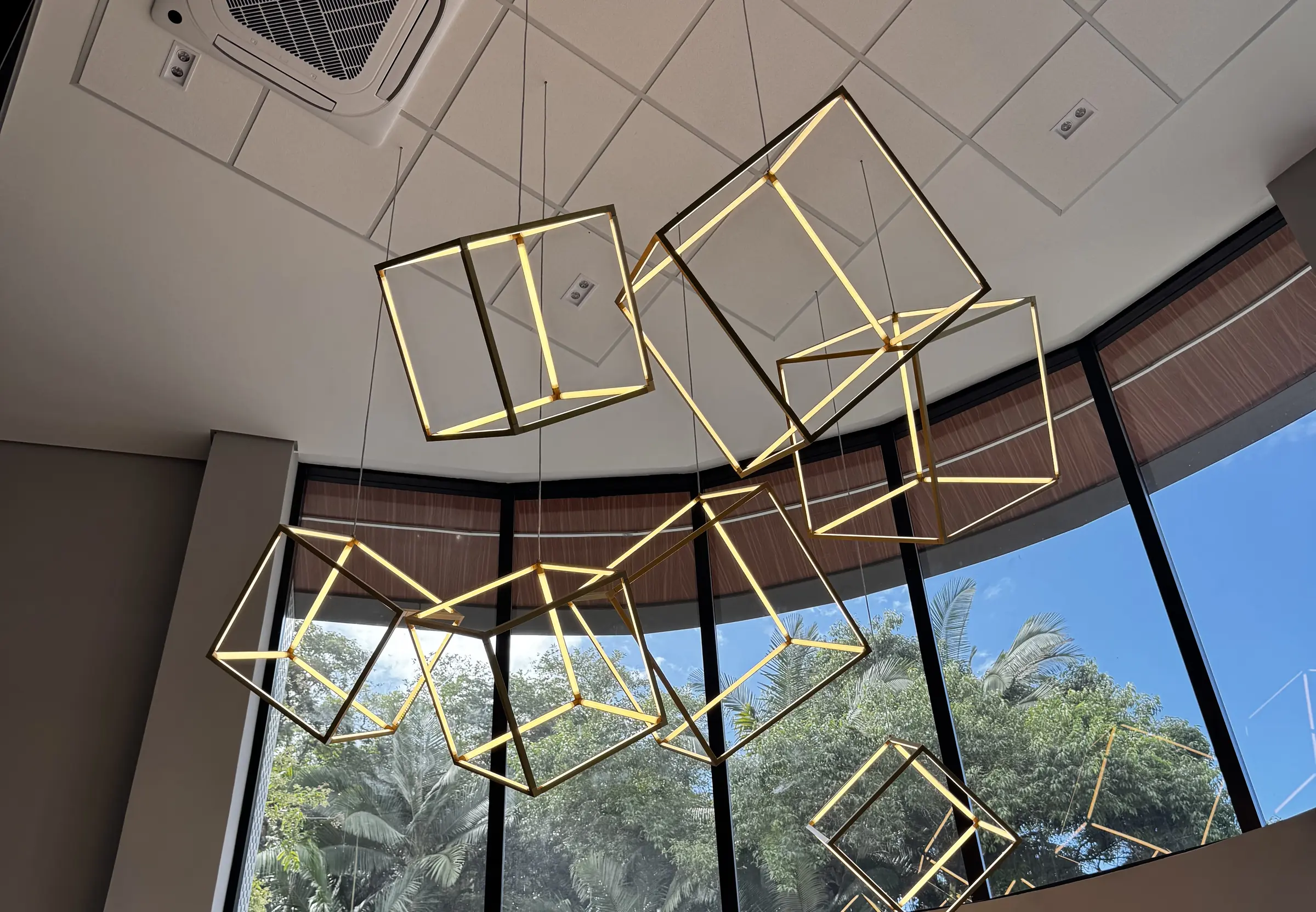 Fachada envidraçada com estrutura metálica e luminárias geométricas, obra conduzida pela RAK Engenharia